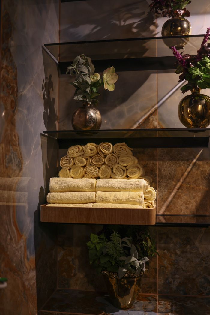 Services Luxurious bathroom shelf with rolled towels and elegant flower vases.